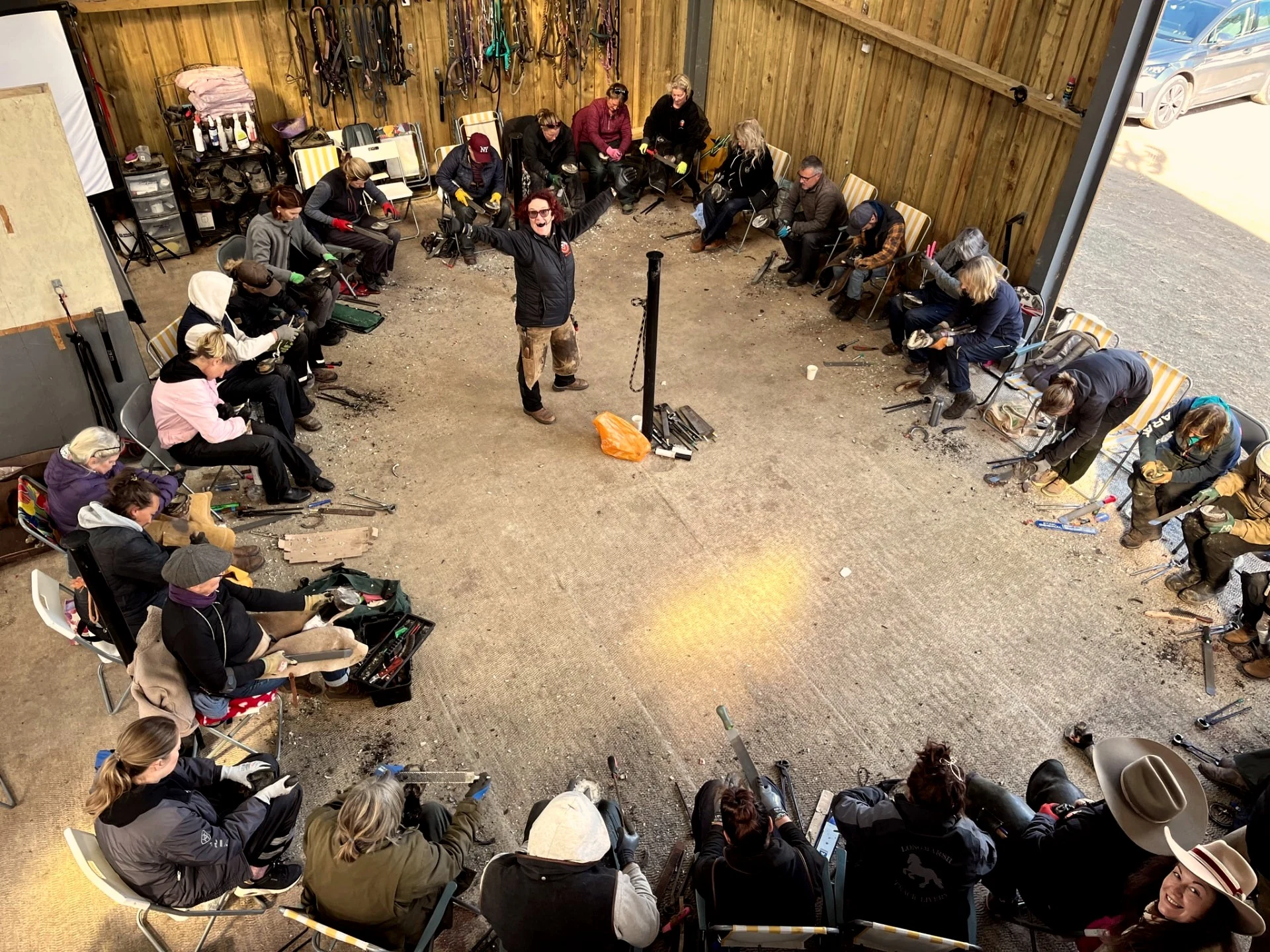Overhead view of an HM workshop - participants seated in a circle working on hooves
