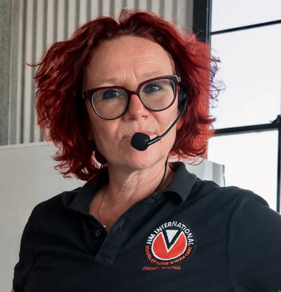 Lindsay Setchell, wearing an HM International polo shirt and headset microphone